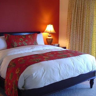Imagen de habitación de invitados tropical con paredes rojas y moqueta