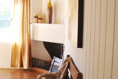 フェニックスにある中くらいなトランジショナルスタイルのおしゃれな主寝室 (白い壁、コンクリートの床、コーナー設置型暖炉、レンガの暖炉まわり)