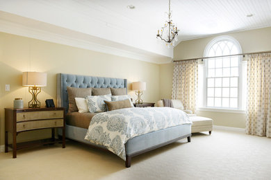 Inspiration for a large classic master bedroom in New York with beige walls and carpet.