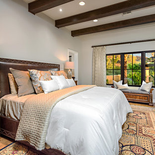 Design ideas for a mediterranean master bedroom in Phoenix with no fireplace, grey walls and medium hardwood flooring.