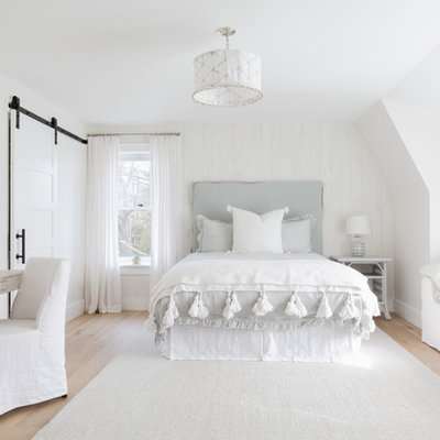 Inspiration for a large coastal guest light wood floor and beige floor bedroom remodel in Boston with beige walls
