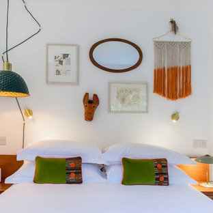 Photo of an eclectic bedroom in London with white walls.