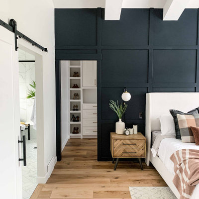 Inspiration for a large transitional master medium tone wood floor and brown floor bedroom remodel in Other with black walls and no fireplace