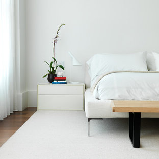 Modernes Schlafzimmer mit weißer Wandfarbe und braunem Holzboden in New York