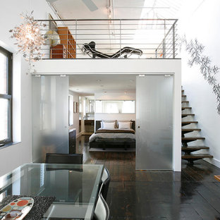 Modelo de dormitorio tipo loft con paredes blancas, suelo de madera oscura y suelo negro