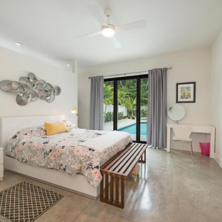 Imagen de dormitorio principal, minimalista, de tamaño medio, con paredes blancas y suelo de cemento