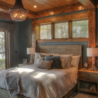 Imagen de habitación de invitados rural, de tamaño medio, con paredes grises, suelo de madera en tonos medios y suelo marrón