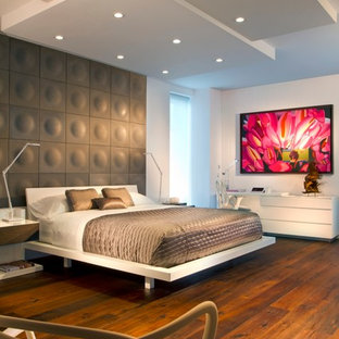 Modernes Schlafzimmer mit weißer Wandfarbe, braunem Holzboden und orangem Boden in Miami