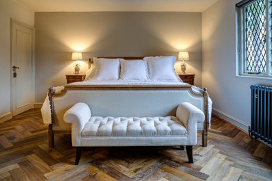 Inspiration for a medium sized traditional master bedroom in Surrey with grey walls, dark hardwood flooring and brown floors.