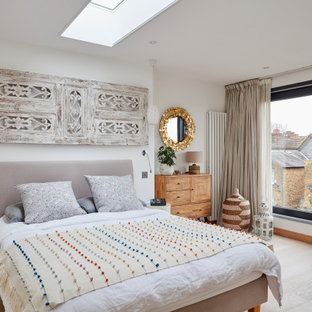 Design ideas for a contemporary guest bedroom in London with white walls and light hardwood flooring.