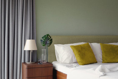 Ejemplo de dormitorio principal minimalista de tamaño medio con paredes verdes, suelo de madera clara y suelo beige