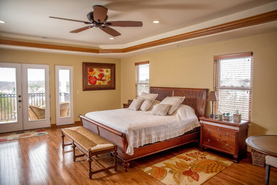 This is an example of a large world-inspired master bedroom in DC Metro with beige walls, medium hardwood flooring, no fireplace and brown floors.