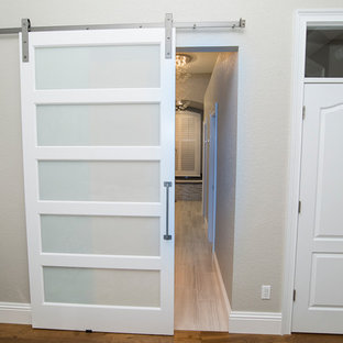 Example of a mid-sized trendy master medium tone wood floor and brown floor bedroom design in Orlando with gray walls and no fireplace