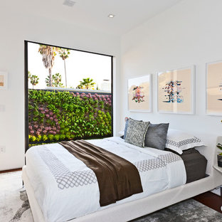 Example of a trendy medium tone wood floor bedroom design in Los Angeles with white walls