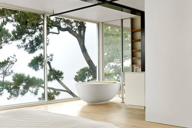 Example of a mid-sized trendy master laminate floor and brown floor bedroom design in San Francisco with white walls