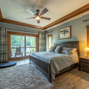 This is an example of a mid-sized arts and crafts master bedroom in Milwaukee with blue walls, ceramic floors and brown floor.