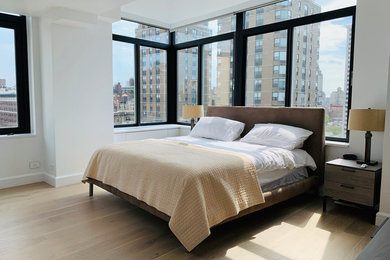 Diseño de dormitorio principal minimalista de tamaño medio con paredes blancas, suelo de madera clara y suelo multicolor