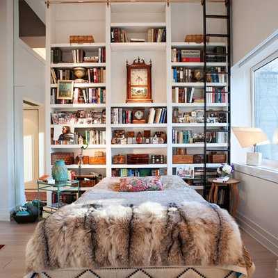 Inspiration for an eclectic light wood floor bedroom remodel in New York with white walls and no fireplace