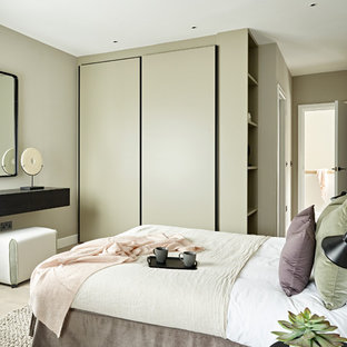 Imagen de habitación de invitados contemporánea, de tamaño medio, sin chimenea, con suelo beige, suelo de madera clara y paredes grises