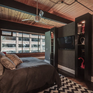 Imagen de dormitorio principal, industrial, de tamaño medio, sin chimenea, con paredes negras, suelo de madera pintada y suelo marrón