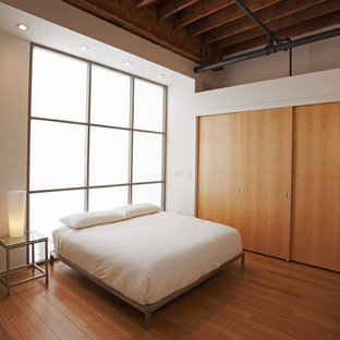 Modelo de dormitorio tipo loft, moderno, con paredes blancas y suelo de bambú