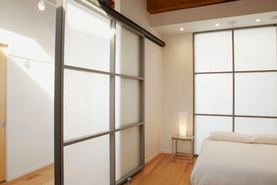 На фото: спальня в стиле лофт с белыми стенами и полом из бамбука с