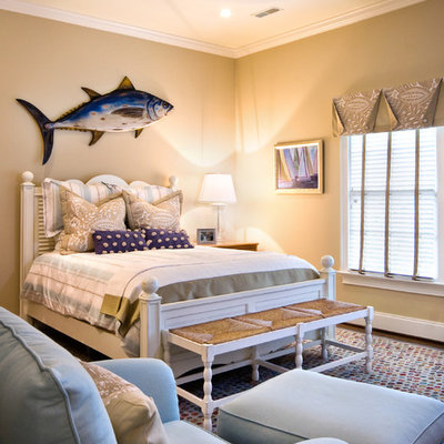 Example of a large beach style guest dark wood floor and brown floor bedroom design in Charleston with beige walls
