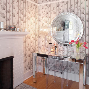 Idée de décoration pour une chambre design avec un mur beige, un sol en bois brun, une cheminée standard et un manteau de cheminée en brique.