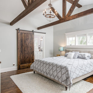 Imagen de dormitorio principal, de estilo americano, grande, con paredes azules, suelo de madera en tonos medios y suelo marrón