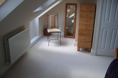 Inspiration for a medium sized modern mezzanine bedroom in Gloucestershire with white walls and carpet.