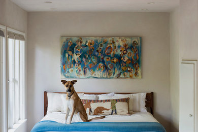 Diseño de dormitorio vintage con paredes beige y suelo de madera en tonos medios