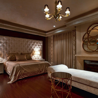 Large transitional master dark wood floor bedroom photo in Los Angeles with beige walls, a standard fireplace and a stone fireplace