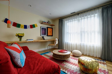 Modelo de dormitorio tipo loft contemporáneo grande con paredes beige y suelo de madera clara