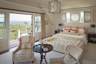Modelo de dormitorio principal clásico renovado con paredes beige y suelo de madera en tonos medios