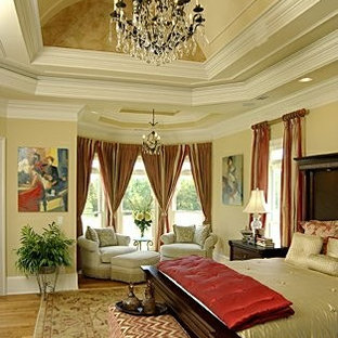 Modelo de dormitorio principal, clásico, grande, con paredes beige y suelo de madera clara