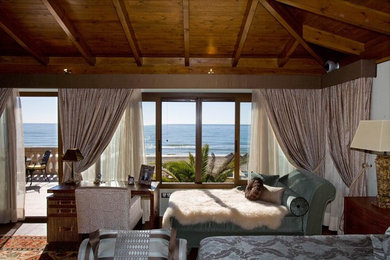 Modelo de dormitorio principal romántico grande con paredes beige, suelo de madera oscura, suelo marrón, vigas vistas y papel pintado