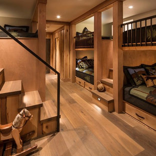 Imagen de habitación de invitados rural, de tamaño medio, con suelo de madera en tonos medios, suelo marrón y paredes marrones
