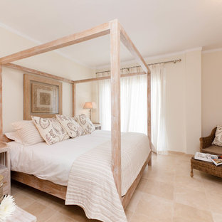 Ejemplo de dormitorio principal, mediterráneo, de tamaño medio, sin chimenea, con paredes beige y suelo de travertino