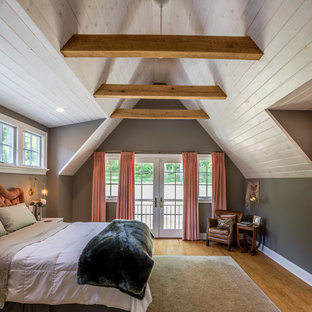 Ejemplo de dormitorio principal, de estilo de casa de campo, con paredes grises, suelo de madera en tonos medios y suelo marrón