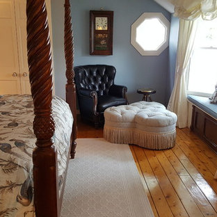 Imagen de dormitorio principal, tradicional, grande, sin chimenea, con paredes azules, suelo de madera en tonos medios y suelo marrón