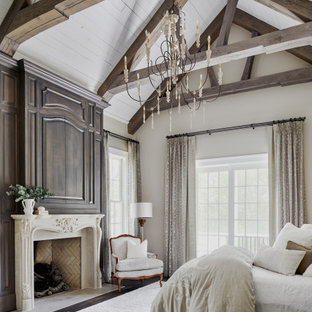 Idee per una camera da letto con pareti beige, parquet scuro, camino classico, pavimento marrone, travi a vista e soffitto a volta