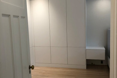 Foto på ett stort funkis huvudsovrum, med vita väggar och ljust trägolv