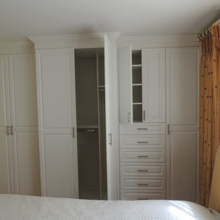 Modelo de dormitorio principal, rústico, de tamaño medio, con paredes amarillas y suelo de madera oscura
