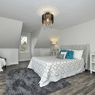 Modelo de dormitorio principal, minimalista, de tamaño medio, con paredes grises, suelo laminado y suelo gris