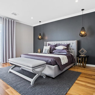 This is an example of a mid-sized contemporary bedroom in Perth with multi-coloured walls, medium hardwood floors and brown floor.