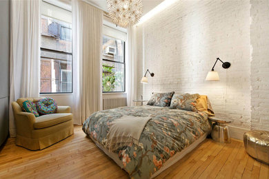 ニューヨークにある中くらいなインダストリアルスタイルのおしゃれな客用寝室 (白い壁、淡色無垢フローリング、暖炉なし) のインテリア