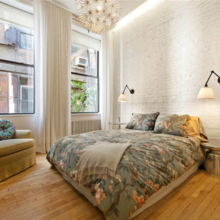 Example of a mid-sized urban guest light wood floor bedroom design in New York with white walls and no fireplace