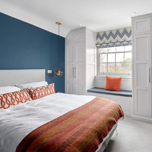 Design ideas for a medium sized traditional master bedroom in West Midlands with blue walls, carpet and grey floors.