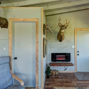 Idee per una camera degli ospiti stile rurale di medie dimensioni con pareti grigie, pavimento in legno massello medio, camino sospeso e pavimento marrone