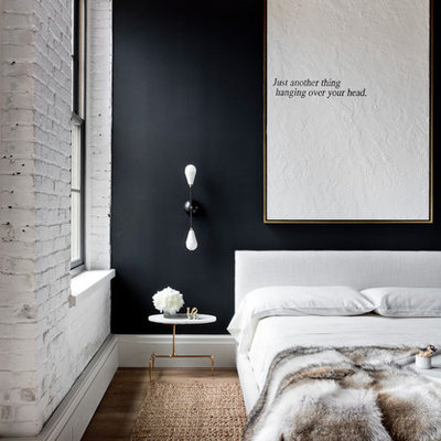 Example of an urban bedroom design in New York with black walls